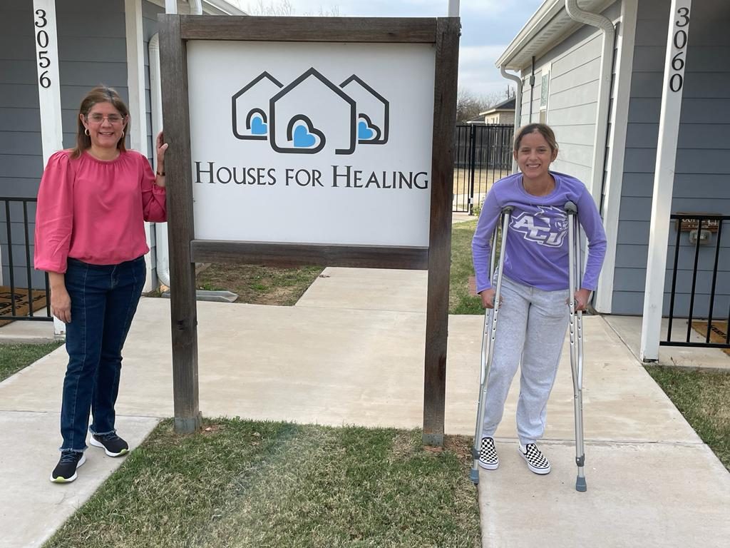 Guests standing at the Houses for Healing sign