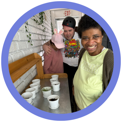 A group of people standing next to a table with small white potsAI-generated content may be incorrect.