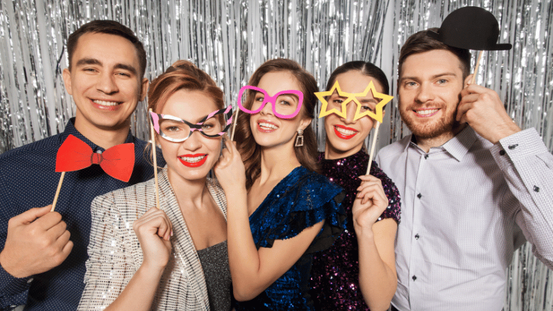 Group of adults using a photo booth at a giving season event.